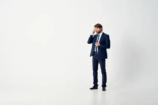 Мужчина в деловом костюме говорит по телефону на белом фоне