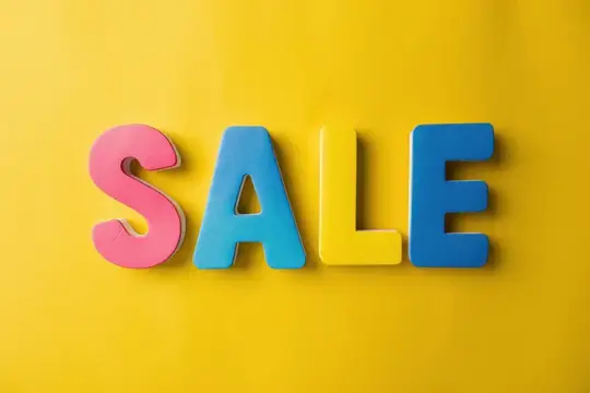 Разноцветные объёмные буквы SALE на жёлтом фоне