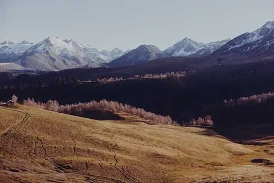 Снежные горы и осенние холмы с сухой травой