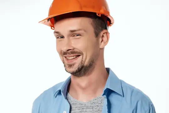 Улыбающийся мужчина в оранжевой каске на белом фоне