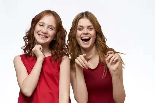 Весёлая мама и дочка обнимаются, излучая радость