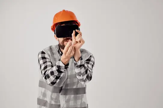 Строитель в каске и VR-очках настраивает виртуальную реальность