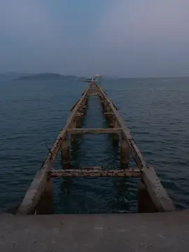 Старый бетонный пирс уходит в туманное море