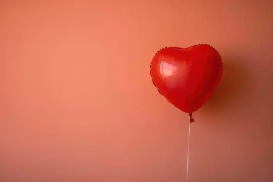 Красный воздушный шар в форме сердца на розовом фоне