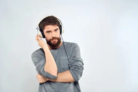 Мужчина в наушниках слушает музыку, образ жизни, досуг, светлый фон