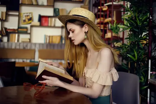 Весёлая женщина читает книгу в кафе, общаясь