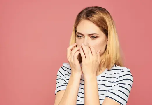 Расстроенная женщина с blond волосами на розовом фоне в модной футболке