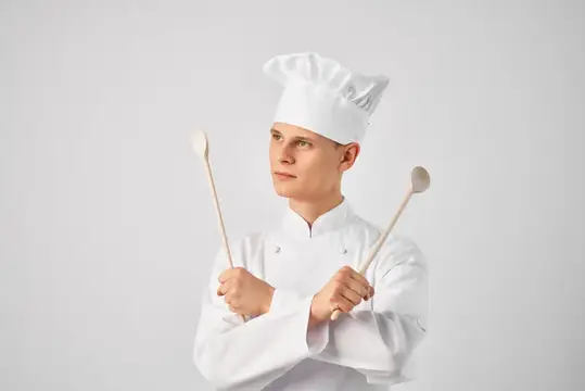 Весёлый шеф-повар-мужчина с кухонной утварью, работающий в ресторане, персонал