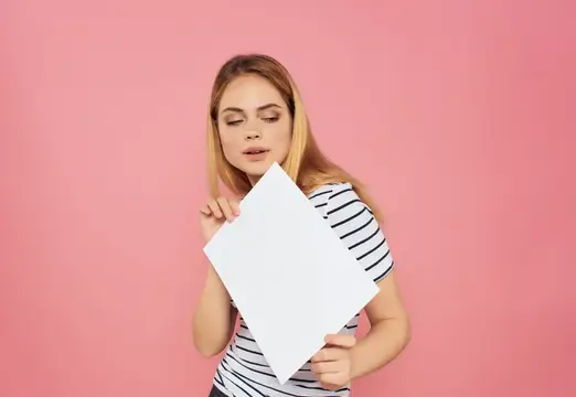 Молодая блондинка с белым листом на розовом фоне