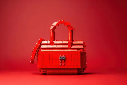 Креативная, привлекающая внимание красная сумочка из кубиков LEGO на соответствующем красном фоне, демонстрирующая художественное мастерство