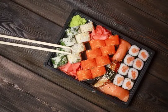 Роллы суши, азиатская кухня, деревянный стол, васаби и имбирь