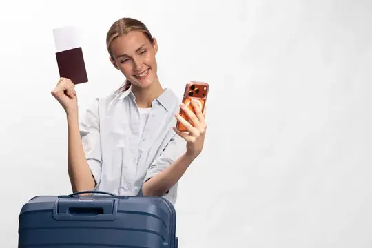 Улыбающаяся девушка с паспортом и телефоном у чемодана