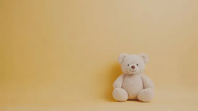 Белый плюшевый мишка сидит на жёлтом фоне