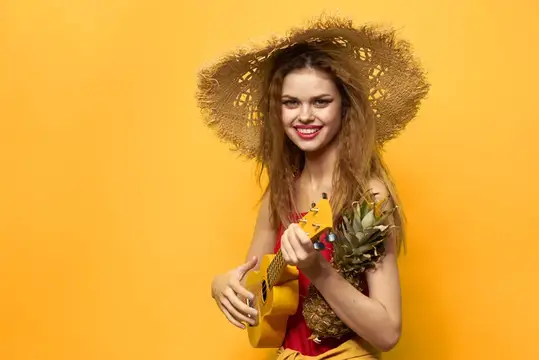 Улыбчивая девушка в соломенной шляпе с укулеле и ананасом