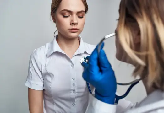 Медицинская сестра со стетоскопом выполняет лечебные процедуры на изолированном фоне