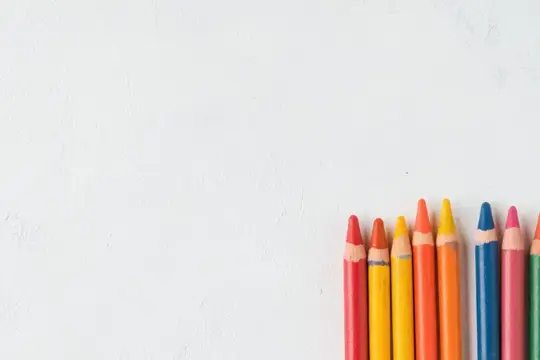 Цветные карандаши стоят в ряд на белом фоне