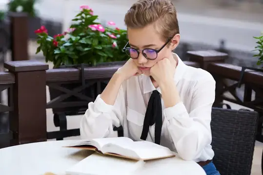 Студент с книгой в руках на открытом воздухе, читает, образование