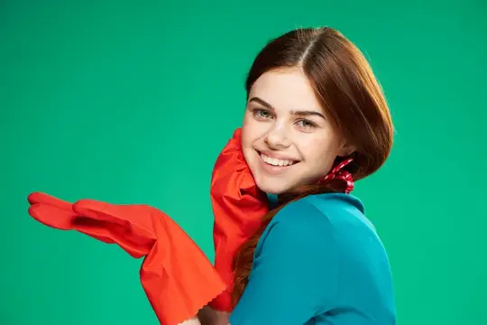 Улыбающаяся девушка в красных перчатках на зелёном фоне