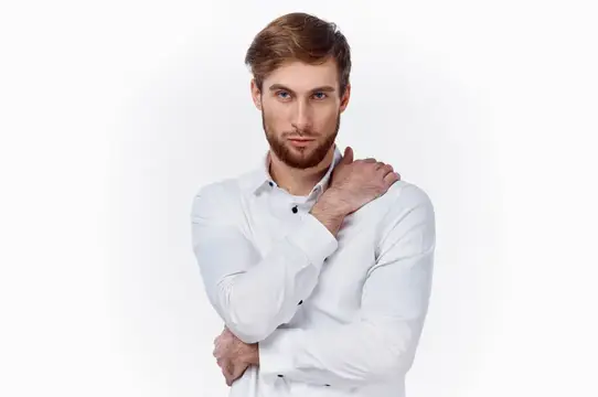 Молодой мужчина с бородой в белой рубашке на белом фоне
