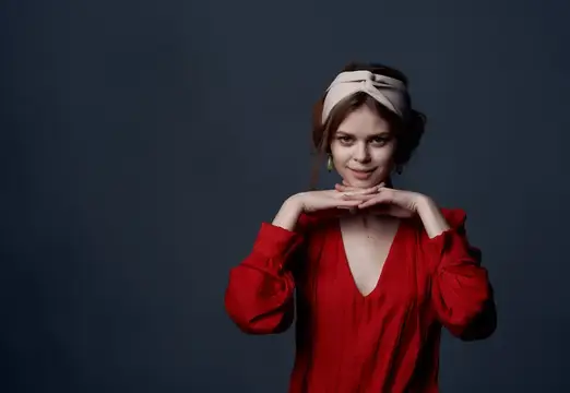 Молодая женщина в красном платье с повязкой на голове