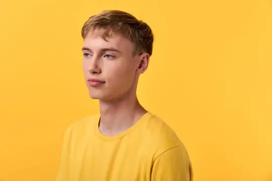 Светловолосый парень в жёлтой футболке на жёлтом фоне