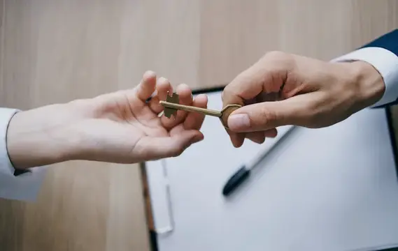 Передача ключа из рук в руки в офисе, бизнес, финансы, работа с документами
