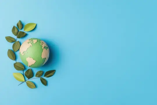Макет планеты Земля с зелёными листьями на голубом фоне