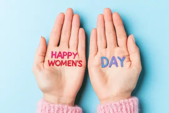 Ладони с надписью Happy Women's Day на голубом фоне