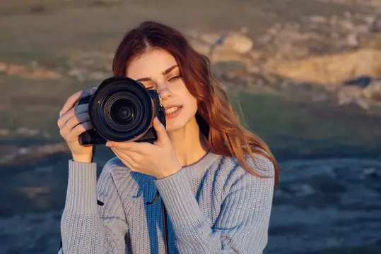 Женщина-турист с фотоаппаратом наслаждается пейзажем и природой во время отпуска и путешествия