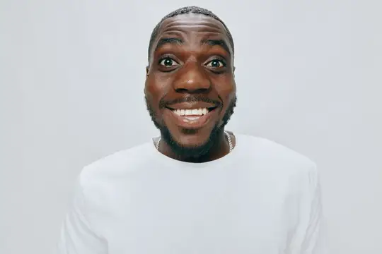 Улыбающийся темнокожий мужчина с широкой улыбкой на светлом фоне