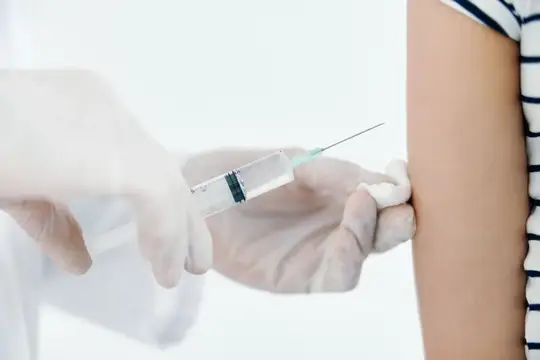 Врач делает укол в плечо, вакцинация для здоровья