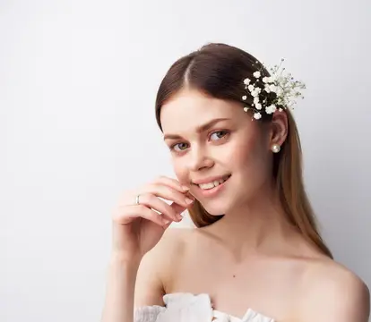 Весёлая женщина с привлекательным взглядом, в волосах которой вплетены цветы