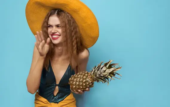 Улыбающаяся женщина в шляпе, экзотические фрукты, ананас, тропики, синий фон