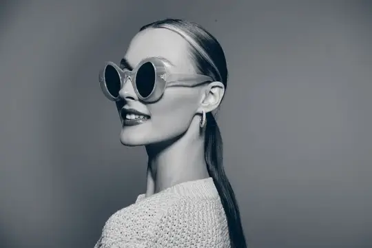 Улыбающаяся девушка в круглых солнцезащитных очках