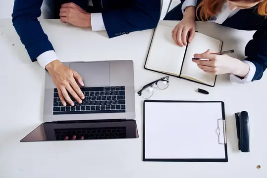 Деловой мужчина и женщина работают за ноутбуком в офисе