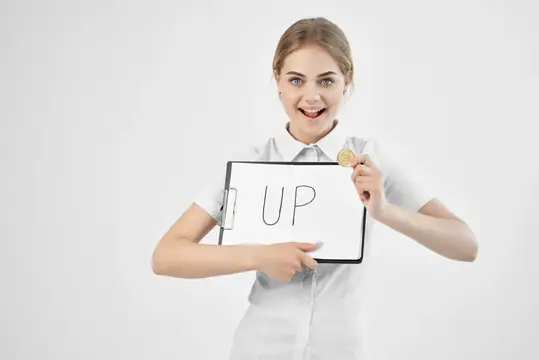 Улыбающаяся девушка в белой рубашке держит планшет с надписью UP