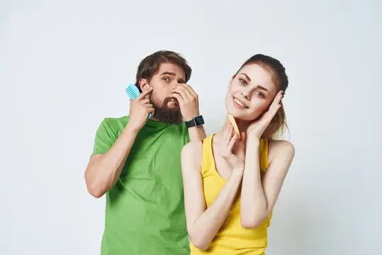 Молодые люди с расческами у лица на светлом фоне