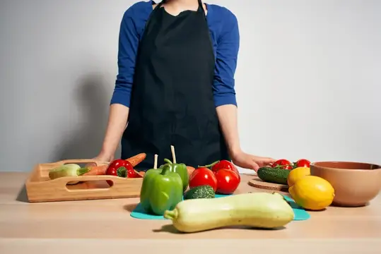 Женщина на кухне нарезает овощи на изолированном фоне