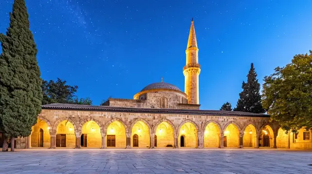 Старинная мечеть с минаретом и аркадой в сумерках