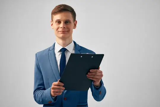 Молодой человек в синем костюме с папкой в руках