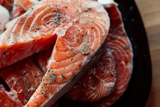 Маринованная красная рыба на тарелке на деревянном фоне