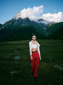 Горы, луг, женщина, outdoor-мода, пейзаж, природа, приключения с красными брюками и белым топом в бескрайней долине