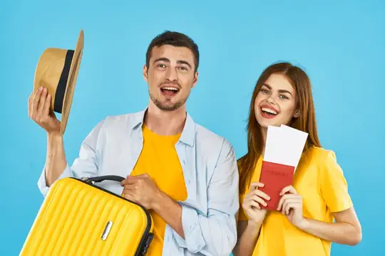 Улыбающиеся парень с чемоданом и девушка с билетами на голубом фоне