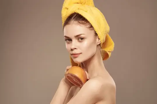 Женщина с грейпфрутом в руке, чистая кожа, обнажённые плечи, спа-процедуры для здоровья