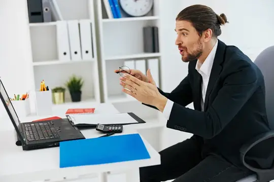 Бизнесмен работает с документами в офисе за ноутбуком, используя современные технологии