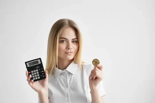 Симпатичная блондинка с калькулятором и золотой монетой, символизирующей криптовалюту и финансы