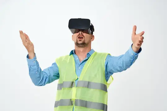 Мужчина в светоотражающем жилете и VR-очках разводит руками