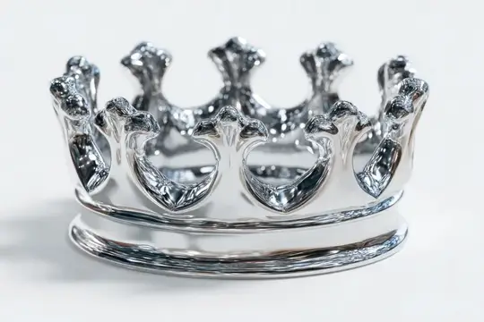 Серебристая корона с резными зубцами на белом фоне