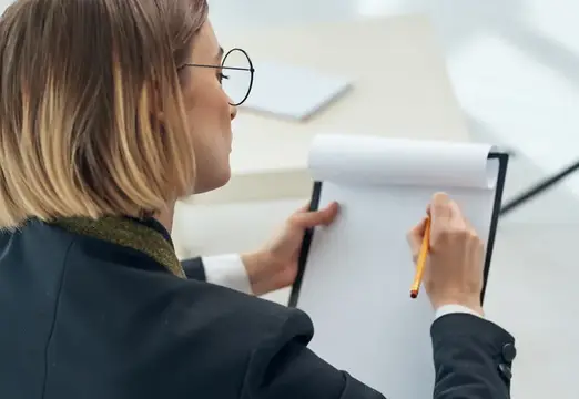 Деловая женщина сидит в кресле и работает с профессиональными документами в офисе