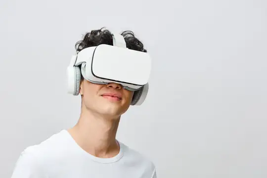 Молодой человек в белом VR-шлеме на светлом фоне